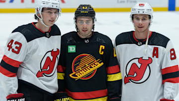 Brothers Luke (left), Quinn (center), and Jack (right) Hughes pose for a photo before a contest between the New Jersey Devils and Vancouver Canucks.