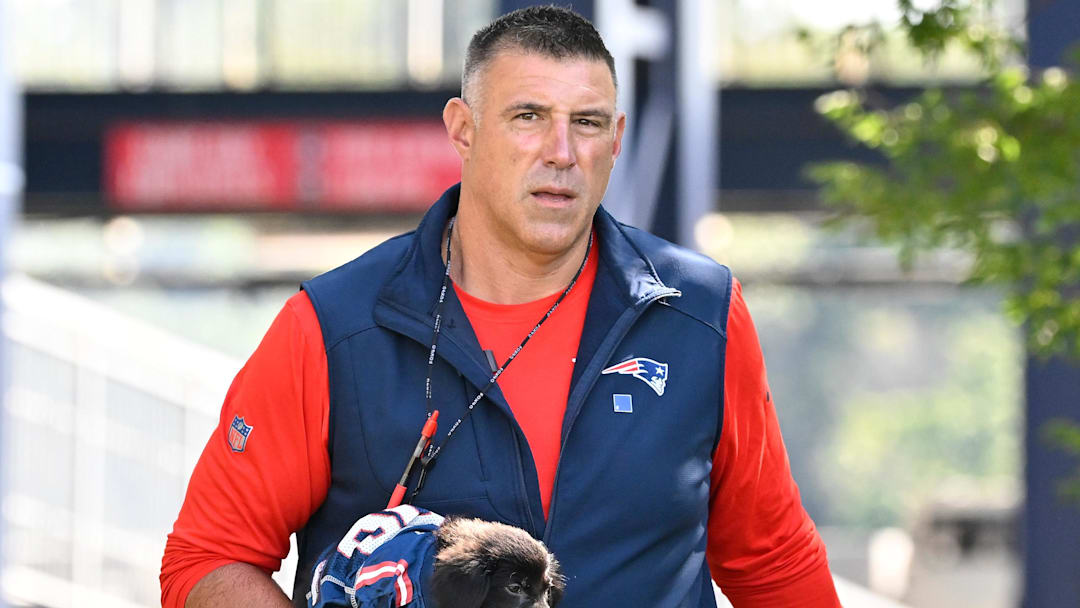 Jul 23, 2025; Foxborough, MA, USA; New England Patriots head coach Mike Vrabel delivers a puppy to a local family before addressing the media during training camp at Gillette Stadium. Mandatory Credit: Eric Canha-Imagn Images