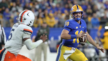 Nov 9, 2024; Pittsburgh, Pennsylvania, USA;  Pittsburgh Panthers quarterback Eli Holstein (10) scrambles with the ball as Virginia Cavaliers linebacker Kam Robinson (5) chases during the second quarter at Acrisure Stadium. Mandatory Credit: Charles LeClaire-Imagn Images