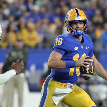 Nov 9, 2024; Pittsburgh, Pennsylvania, USA;  Pittsburgh Panthers quarterback Eli Holstein (10) scrambles with the ball as Virginia Cavaliers linebacker Kam Robinson (5) chases during the second quarter at Acrisure Stadium. Mandatory Credit: Charles LeClaire-Imagn Images
