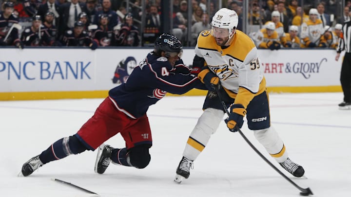 Mar 3, 2026; Columbus, Ohio, USA; Nashville Predators defenseman Roman Josi (59) wrists a shot on goal as Columbus Blue Jackets center Cole Sillinger (4) defends during the third period at Nationwide Arena. Mandatory Credit: Russell LaBounty-Imagn Images