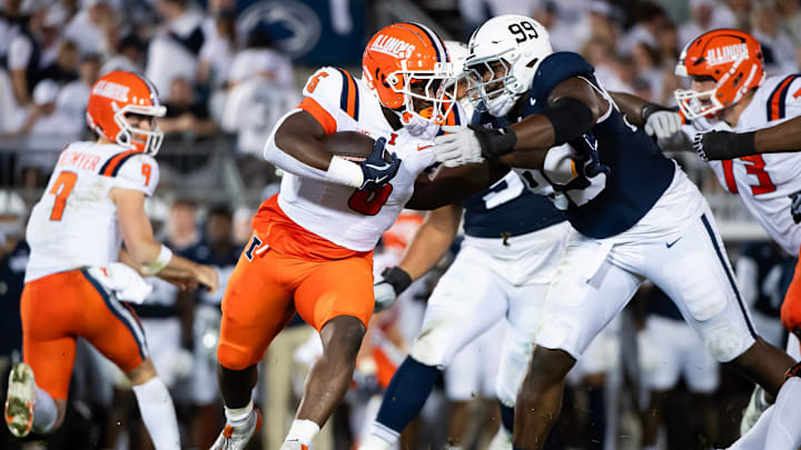 Illinois running back Josh McCray (6) pushes off a tackle from Penn State's Coziah Izzard (99) in the second quarter of a Big Ten football game, Saturday, Sept. 28, 2024, in State College, Pa.
