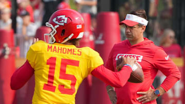 Jul 26, 2024; Kansas City, MO, USA; Kansas City Chiefs quarterback Patrick Mahomes (15) throws a pass as general manager Brett Veach watches in the background during training camp at Missouri Western State University. 