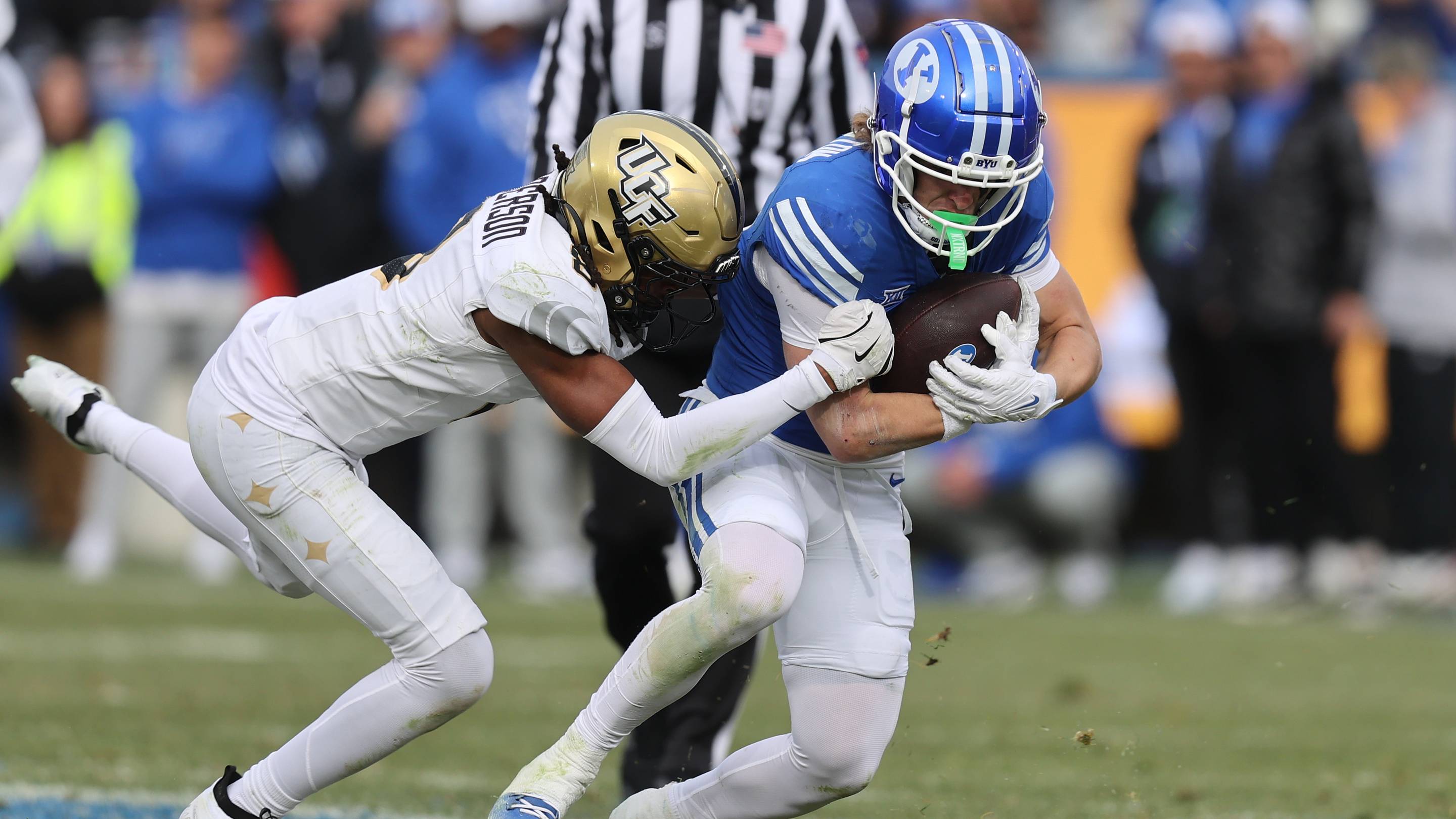 Nov 29, 2025; Provo, Utah, USA; UCF Knights defensive back Braeden Marshall (4) tackled BYU Cougars wide receiver Parker Kingston (11) during the second half at LaVell Edwards Stadium. Mandatory Credit: Rob Gray-Imagn Images | IMAGN IMAGES via Reuters Connect