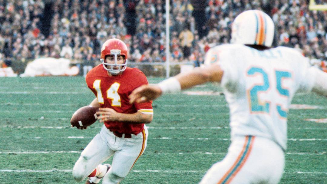 Dec 25, 1971; Kansas City, MO, USA; FILE PHOTO; Kansas City Chiefs running back Ed Podolak (14) carries the ball as Miami Dolphins defensive back Tim Foley (25) closes in in the 1971 AFC Divisional Playoff game at Municipal Stadium. Podolak set an NFL record for a total of 350 yards combined in a single game. The Dolphins defeated the Chiefs 27-24 in overtime. The game was the longest game in NFL history. Mandatory Credit: Dick Raphael-USA TODAY Sports