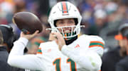 Nov 29, 2025; Pittsburgh, Pennsylvania, USA;  Miami Hurricanes quarterback Carson Beck (11) throws on the sidelines to keep loose during the third quarter against the Pittsburgh Panthers at Acrisure Stadium. Mandatory Credit: Charles LeClaire-Imagn Images