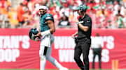 Sep 28, 2025; Tampa, Florida, USA; Philadelphia Eagles offensive coach Kevin Patullo communicates with quarterback Jalen Hurts (1) during a timeout in the second quarter against the Tampa Bay Buccaneers at Raymond James Stadium. Mandatory Credit: Nathan Ray Seebeck-Imagn Images