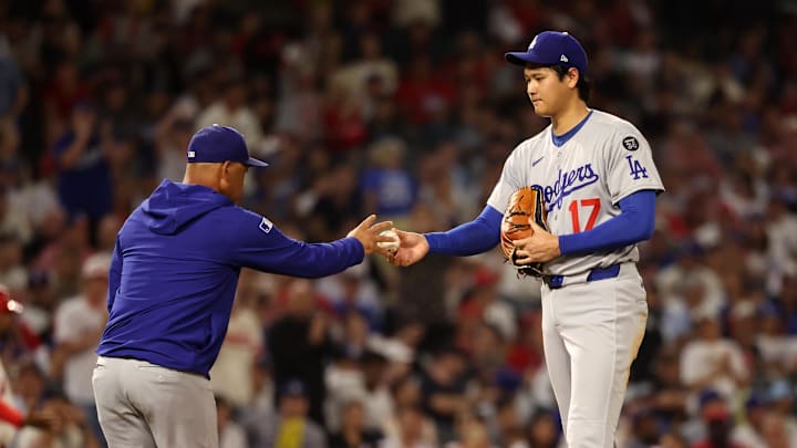 Aug 13, 2025; Anaheim, California, USA; Los Angeles Dodgers two-way player Shohei Ohtani (17) hands the ball to manager Dave Roberts (30, left) during the fifth inning against the Los Angeles Angels at Angel Stadium. Mandatory Credit: Kiyoshi Mio-Imagn Images Aug 13, 2025; Anaheim, California, USA; Los Angeles Dodgers two-way player Shohei Ohtani (17) hands the ball to manager Dave Roberts (30, left) during the fifth inning against the Los Angeles Angels at Angel Stadium. Mandatory Credit: Kiyoshi Mio-Imagn Images