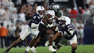Sep 27, 2025; University Park, Pennsylvania, USA; Oregon Ducks running back Dierre Hill Jr. (23) runs for a gain past Penn State Nittany Lions linebacker Amare Campbell (24) during the second quarter at Beaver Stadium. Mandatory Credit: Matthew O'Haren-Imagn Images