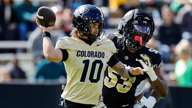 Colorado Buffaloes quarterback Julian Lewis (10) and defensive end Arden Walker (53) during the spring game at Folsom Field. 