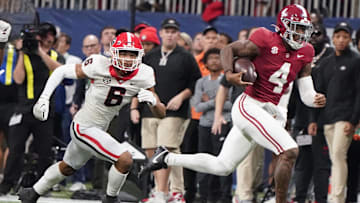 Dec 2, 2023; Atlanta, GA, USA;  Alabama Crimson Tide quarterback Jalen Milroe (4) runs for a first down with Georgia Bulldogs defensive back Daylen Everette (6) pursuing at Mercedes-Benz Stadium. Alabama defeated Georgia 27-24 to claim the SEC Championship. Mandatory Credit: Gary Cosby Jr.-Imagn Images