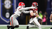 Dec 6, 2025; Atlanta, GA, USA; Alabama Crimson Tide quarterback Ty Simpson (15) scrambles and is tackled by Georgia Bulldogs linebacker Zayden Walker (10) during the fourth quarter during the 2025 SEC Championship game at Mercedes-Benz Stadium. Mandatory Credit: Brett Davis-Imagn Images