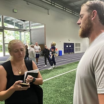 Carver Willis answer post-practice questions in Dempsey Indoor. 