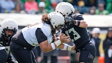 Fighting Ducks offensive lineman Lipe Moala, left, blocks Combat Ducks inside linebacker Brayden Platt as the Fighting Ducks face off against Mighty Oregon in the Oregon Ducks spring game on April 26, 2025, at Autzen Stadium in Eugene.