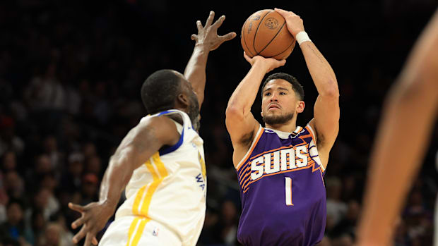 Phoenix Suns Guard Devin Booker (1) pulls the ball on Golden State Warriors attacker Draymond Green