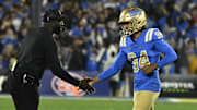 Nov 23, 2024; Pasadena, California, USA; UCLA Bruins place kicker Mateen Bhaghani (94) high fives head coach DeShaun Foster after hitting a first quarter field goal against the USC Trojans at Rose Bowl. Mandatory Credit: Robert Hanashiro-Imagn Images