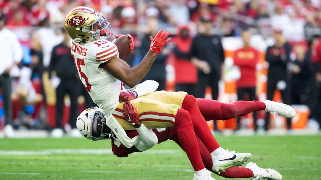 Jan 5, 2025; Glendale, Arizona, USA; San Francisco 49ers wide receiver Jauan Jennings (15) is tackled by Arizona Cardinals cornerback Garrett Williams (21) at State Farm Stadium. Mandatory Credit: Mark J. Rebilas-Imagn Images