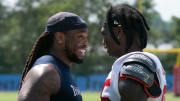 Tennessee Titans running back Derrick Henry (22) shares a laugh with Tampa Bay Buccaneers wide receiver Julio Jones (85) after a joint training camp practice at Ascension Saint Thomas Sports Park Thursday, Aug. 18, 2022, in Nashville, Tenn.