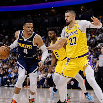 Mar 14, 2025; Denver, Colorado, USA; Denver Nuggets guard Russell Westbrook (4) controls the ball as Los Angeles Lakers center Alex Len (27) guards in the second quarter at Ball Arena. Mandatory Credit: Isaiah J. Downing-Imagn Images