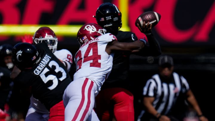 Oklahoma Sooners defensive lineman Adepoju Adebawore (34) knocks the ball loose as Cincinnati Bearcats quarterback Emory Jones (5) throws in the third quarter of the NCAA Big 12 football game between the Cincinnati Bearcats and the Oklahoma Sooners at Nippert Stadium in Cincinnati on Saturday, Sept. 23, 2023. The Bearcats lost their first Big 12 football game, 20-6, to the Sooners before a sellout crowd.