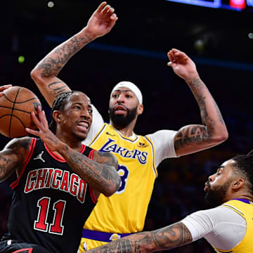 Jan 25, 2024; Los Angeles, California, USA; Chicago Bulls forward DeMar DeRozan (11) moves the ball against Los Angeles Lakers forward Anthony Davis (3) and guard D'Angelo Russell (1) during the second half at Crypto.com Arena. Mandatory Credit: Gary A. Vasquez-Imagn Images