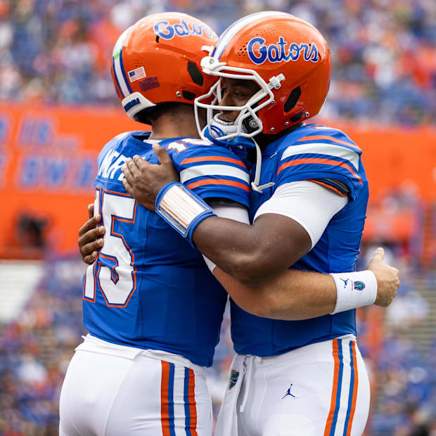 Florida Gators quarterback Graham Mertz (15) and Florida Gators quarterback DJ Lagway (2) embrace before a game.