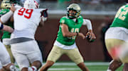 Buford quarterback Dayton Raiola (10) looks to pass as Milton's Christian Hunter applies the pass rush in the 2025 Georgia high school opener, won by 