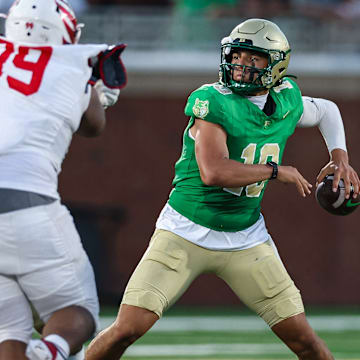 Buford quarterback Dayton Raiola (10) looks to pass as Milton's Christian Hunter applies the pass rush in the 2025 Georgia high school opener.