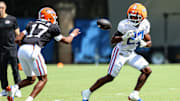 Tramell Jones Jr. pitches the ball to Byron Louis during the viewing period for the Florida Gators fall camp practice on Aug. 5.