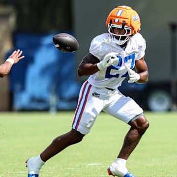 Tramell Jones Jr. pitches the ball to Byron Louis during the viewing period for the Florida Gators fall camp practice on Aug. 5.