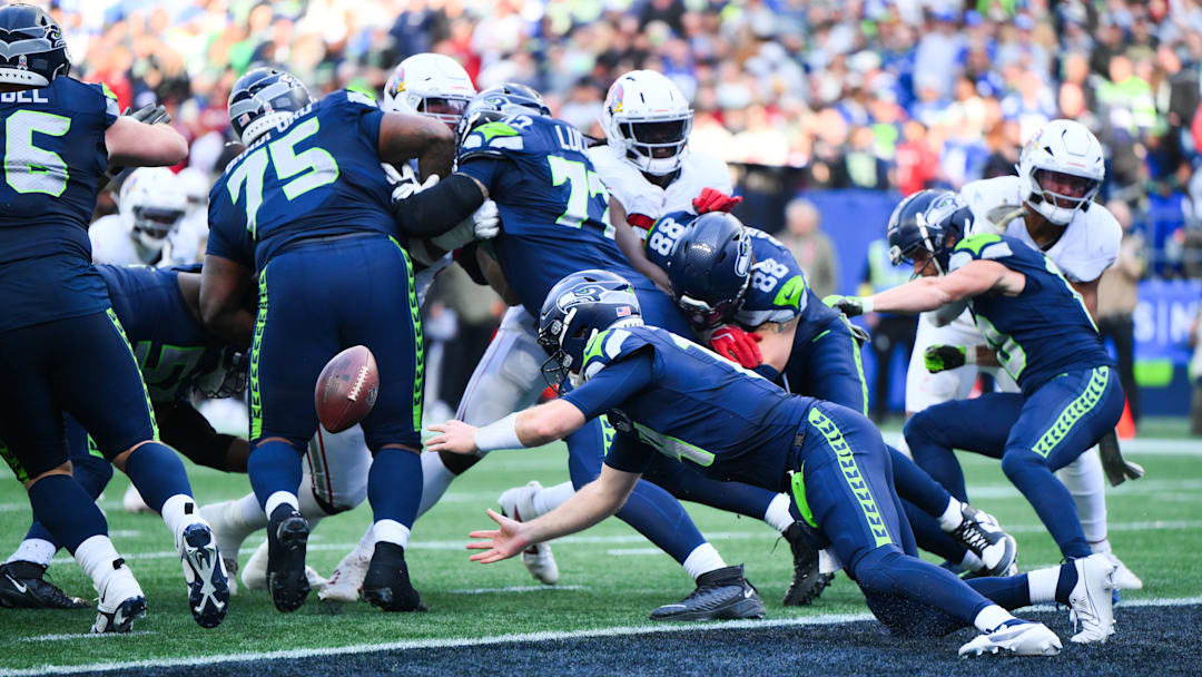 Nov 9, 2025; Seattle, Washington, USA; Seattle Seahawks quarterback Sam Darnold (14) fumbles a snap during the second quarter against the Arizona Cardinals at Lumen Field. 