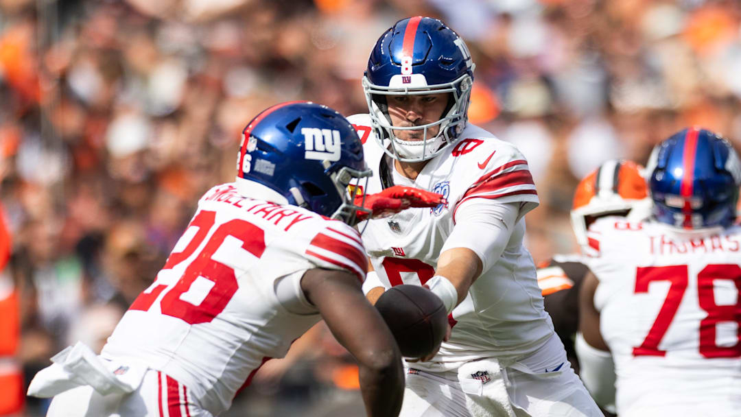 Sep 22, 2024; Cleveland, Ohio, USA; New York Giants quarterback Daniel Jones (8) hands the ball off to running back Devin Singletary (26) during the fourth quarter against the Cleveland Browns at Huntington Bank Field. Mandatory Credit: Scott Galvin-Imagn Images