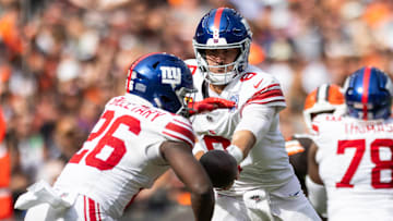 Sep 22, 2024; Cleveland, Ohio, USA; New York Giants quarterback Daniel Jones (8) hands the ball off to running back Devin Singletary (26) during the fourth quarter against the Cleveland Browns at Huntington Bank Field. Mandatory Credit: Scott Galvin-Imagn Images