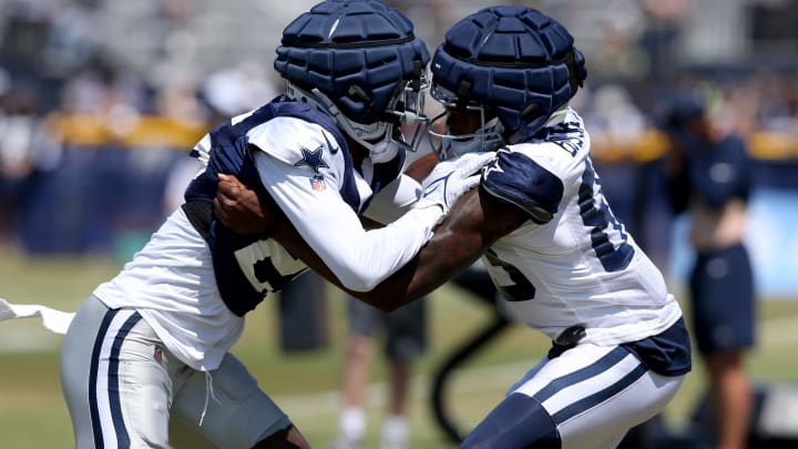 Jul 31, 2024; Oxnard, CA, USA; Dallas Cowboys cornerback Nahshon Wright (25) and wide receiver Jalen Brooks (83) block during training camp at the River Ridge Playing Fields in Oxnard, California.  