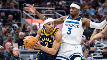 Mar 24, 2025; Indianapolis, Indiana, USA; Indiana Pacers guard Andrew Nembhard (2) dribbles  the ball while Minnesota Timberwolves forward Jaden McDaniels (3) defends in the second half at Gainbridge Fieldhouse. Mandatory Credit: Trevor Ruszkowski-Imagn Images