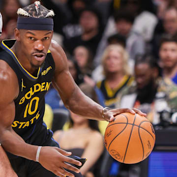 Mar 22, 2025; Atlanta, Georgia, USA; Golden State Warriors forward Jimmy Butler III (10) drives on Atlanta Hawks forward Georges Niang (20) in the fourth quarter at State Farm Arena. Mandatory Credit: Brett Davis-Imagn Images