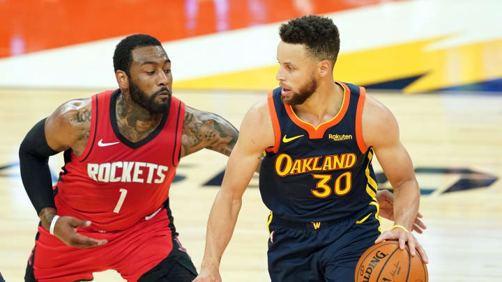 Apr 10, 2021; San Francisco, California, USA; Golden State Warriors guard Stephen Curry (30) dribbles while being defended by Houston Rockets guard John Wall (1) during the second quarter at Chase Center. Mandatory Credit: Darren Yamashita-USA TODAY Sports