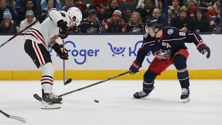 Feb 22, 2025; Columbus, Ohio, USA; Columbus Blue Jackets defenseman Zach Werenski (8) sticks the puck away from Chicago Blackhawks center Ryan Donato (8) during the second period at Nationwide Arena. Mandatory Credit: Russell LaBounty-Imagn Images