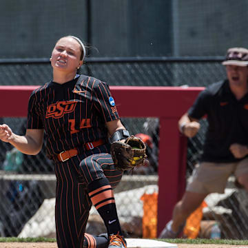 May 17, 2025; Fayetteville, AR, USA;  Oklahoma State Cowgirls infielder Karli Godwin (14) reacts to making a play at first for an out during the fourth inning against the Arkansas Lady Razorbacks.  Mandatory Credit: Brett Rojo-Imagn Images