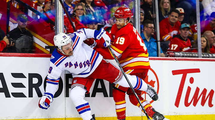 Oct 26, 2025; Calgary, Alberta, CAN; New York Rangers center Sam Carrick (39) and Calgary Flames defenseman Zayne Parekh (19) battles for the puck during the third period at Scotiabank Saddledome. Mandatory Credit: Sergei Belski-Imagn Images
