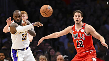 Mar 22, 2025; Los Angeles, California, USA; Los Angeles Lakers forward LeBron James (23) passes to guard Jordan Goodwin (30) against Chicago Bulls forward Zach Collins (12) during the second half at Crypto.com Arena. Mandatory Credit: Jonathan Hui-Imagn Images