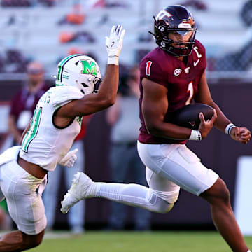 Sep 7, 2024; Blacksburg, Virginia, USA; Virginia Tech Hokies quarterback Kyron Drones (1) scrambles out of the pocket against Marshall Thundering Herd defensive back J.J. Roberts (11) during the second quarter at Lane Stadium. Mandatory Credit: Peter Casey-Imagn Images