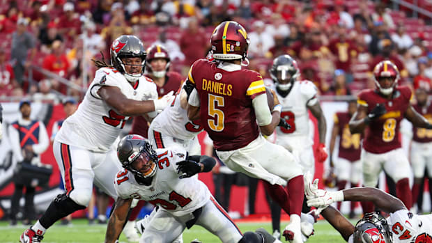 Washington Commanders quarterback Jayden Daniels (5) runs the ball for a touchdown against the Tampa Bay Buccaneers