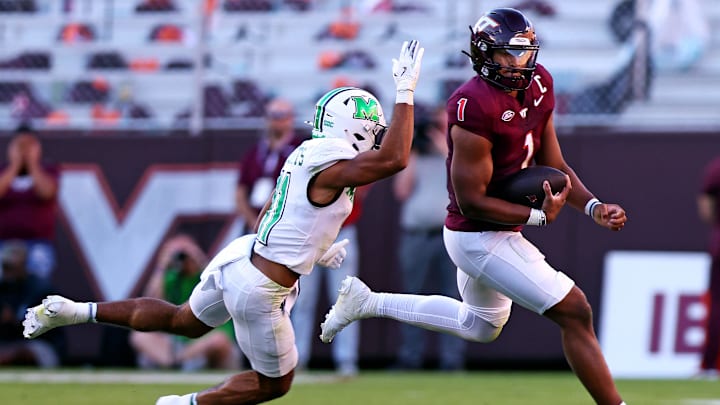 Sep 7, 2024; Blacksburg, Virginia, USA; Virginia Tech Hokies quarterback Kyron Drones (1) scrambles out of the pocket against Marshall Thundering Herd defensive back J.J. Roberts (11) during the second quarter at Lane Stadium. Mandatory Credit: Peter Casey-Imagn Images