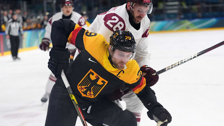 Feb 14, 2026; Milan, Italy; Leon Draisaitl of Germany in action with Zemgus Girgensons of Latvi during a Group C men's ice hockey game during the Milano Cortina 2026 Olympic Winter Games at Milano Rho Ice Hockey Arena. Mandatory Credit: Amber Searls-Imagn Images