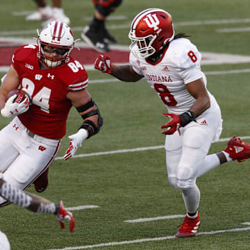Dec 5, 2020; Madison, Wisconsin, USA;  Wisconsin Badgers tight end Jake Ferguson (84) rushes with the football after catching a pass as Indiana Hoosiers linebacker James Miller (8) defends during the second quarter at Camp Randall Stadium.