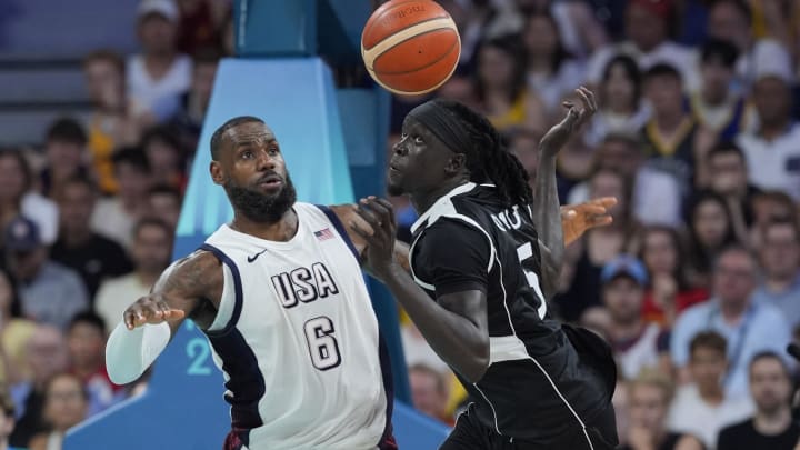 Jul 31, 2024; Villeneuve-d'Ascq, France; United States guard Lebron James (6) and South Sudan small forward Nuni Omot (5) fight for a loose ball in the fourth quarter during the Paris 2024 Olympic Summer Games at Stade Pierre-Mauroy. Mandatory Credit: John David Mercer-USA TODAY Sports