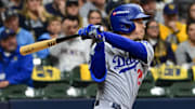 Oct 14, 2025; Milwaukee, Wisconsin, USA; Los Angeles Dodgers second baseman Tommy Edman (25) hits a double against the Milwaukee Brewers in the fourth inning during game two of the NLCS round for the 2025 MLB playoffs at American Family Field. Mandatory Credit: Benny Sieu-Imagn Images
