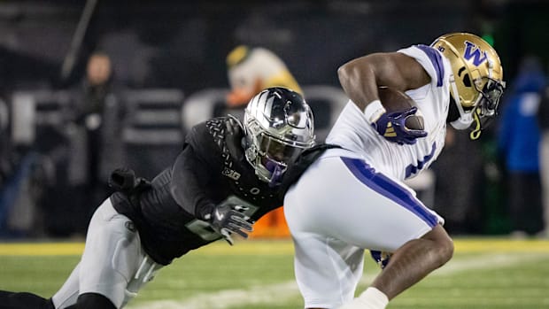Oregon defensive end Jordan Burch tackles Washington running back Jonah Coleman