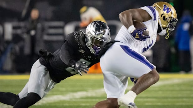 Oregon defensive end Jordan Burch tackles Washington running back Jonah Coleman 